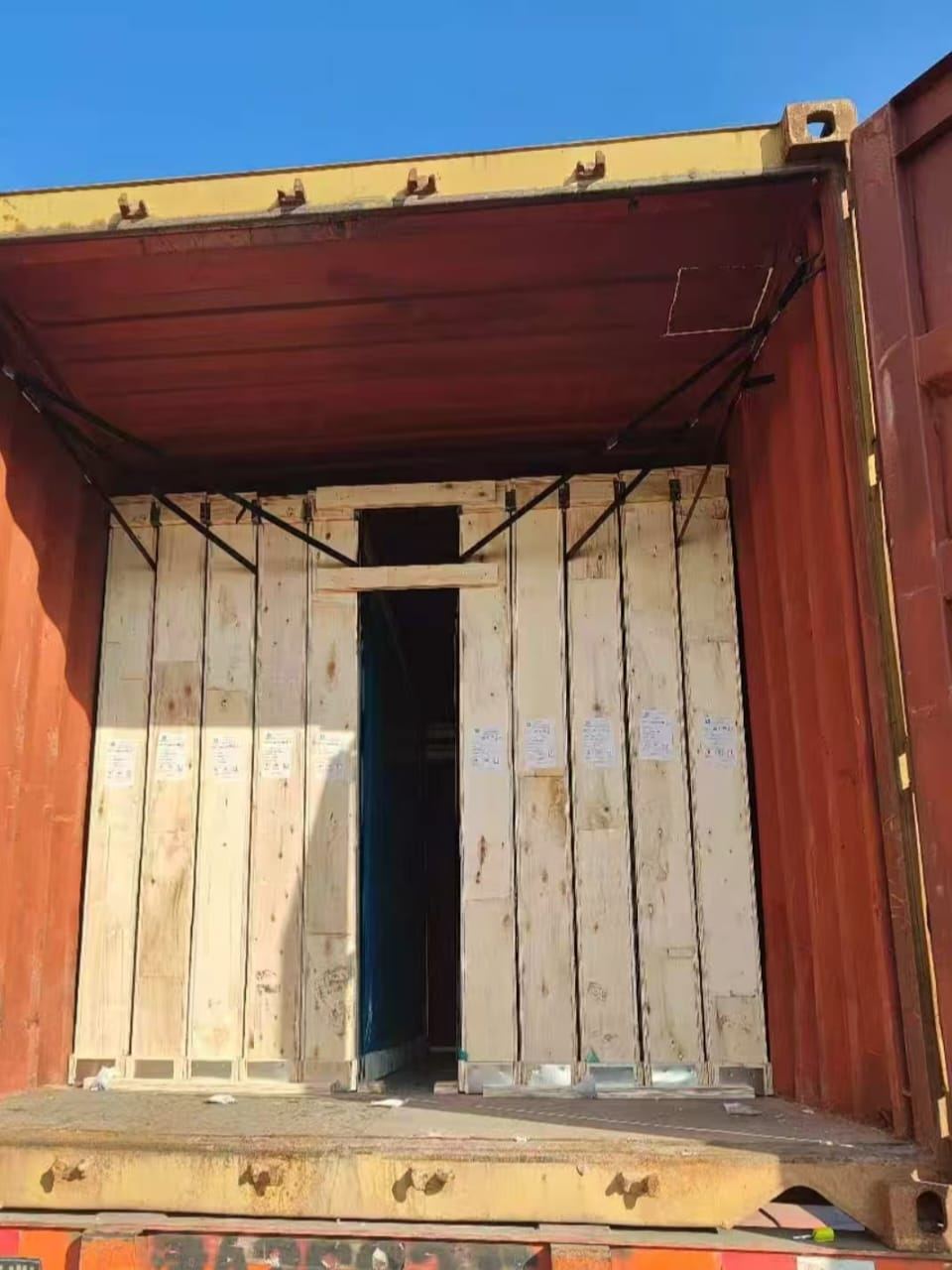 Wooden crates standing upright inside an open shipping container